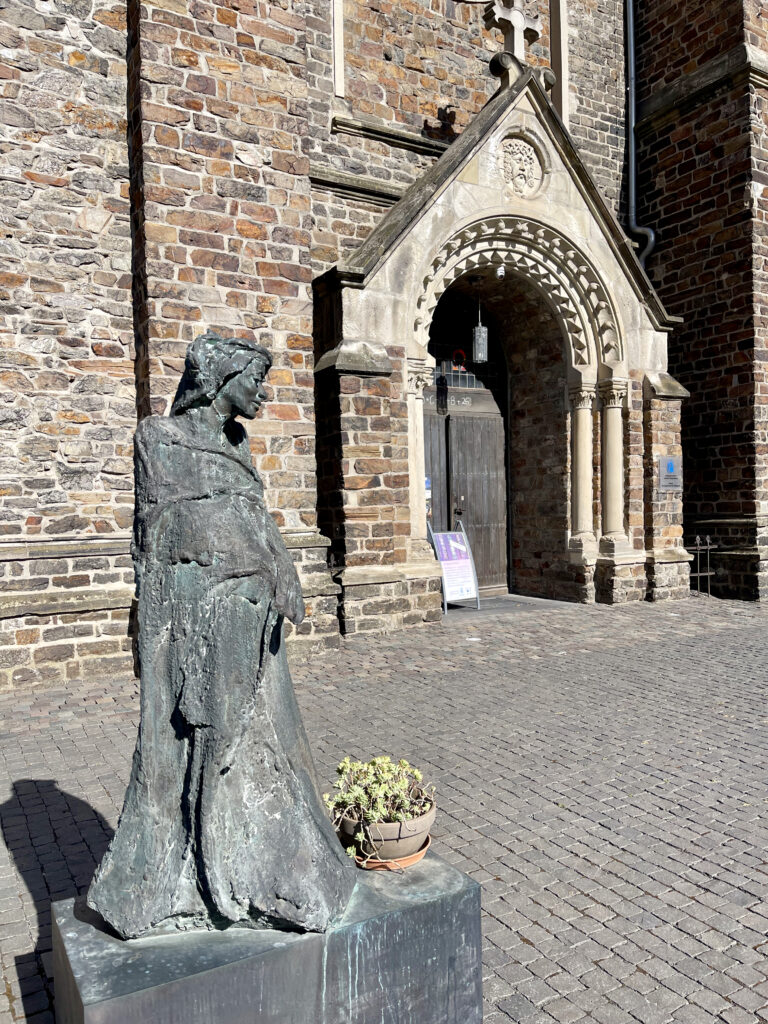 Eingang zur Kirche auf dem Rupertsberg mit Steinfigur von Hildegard von Bingen
