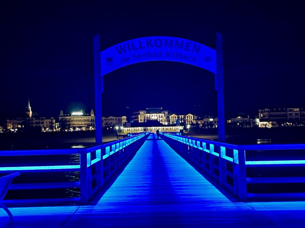 Usedom Erlebnisse. Blau beleuchtete Seebruecke nachts mit Blick auf den Strand und die Promenade von Ahlbeck