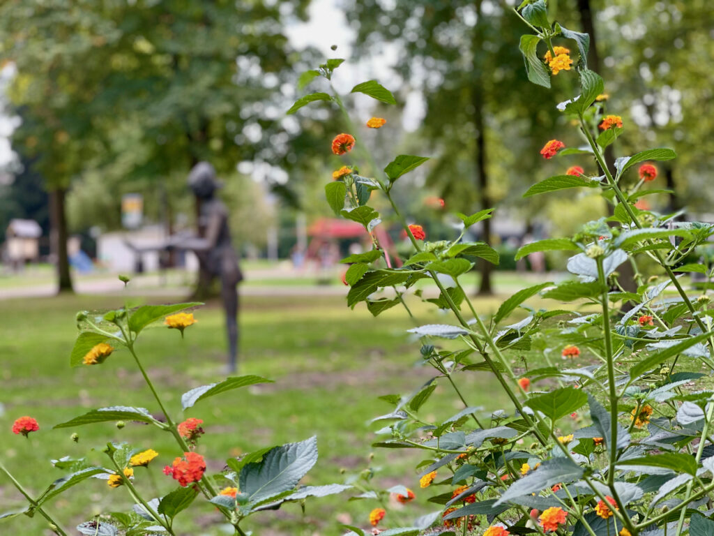 Bronzeplastiken des Sendenhorster Künstlers Bernhard Kleinhans vor bunten Blumenbeeten im Kurpark in Bad Waldliesborn
