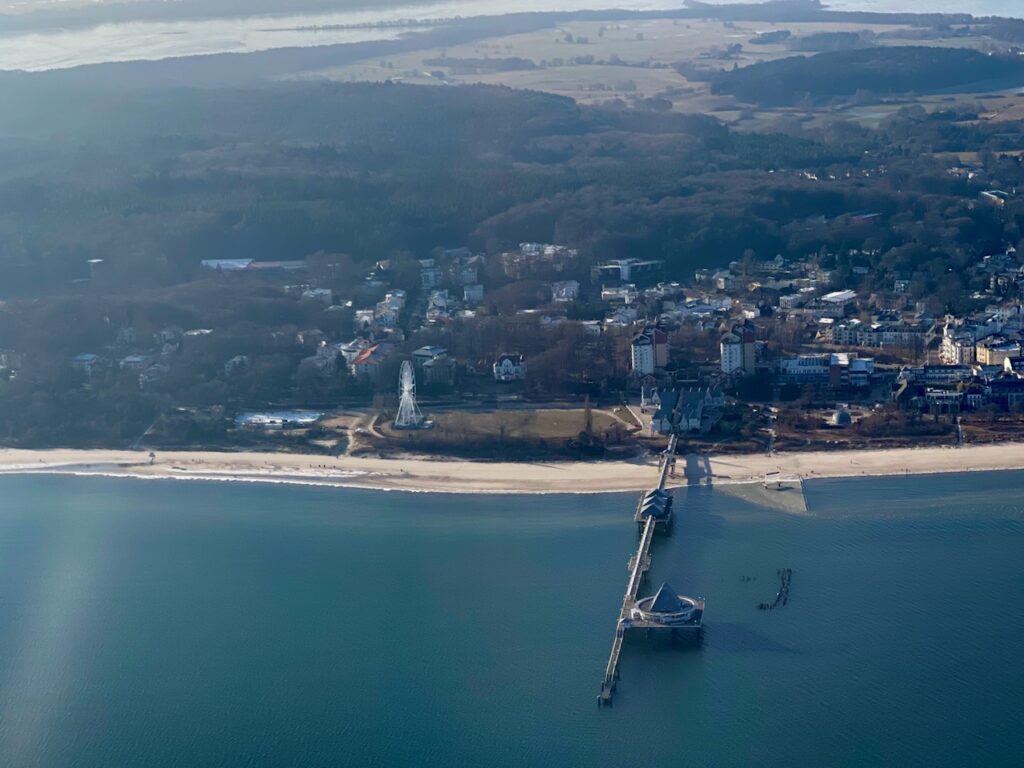 Rundflug Usedom. Blick aus dem Flugzeugfenster ueber Seebruecken und Seebaeder.