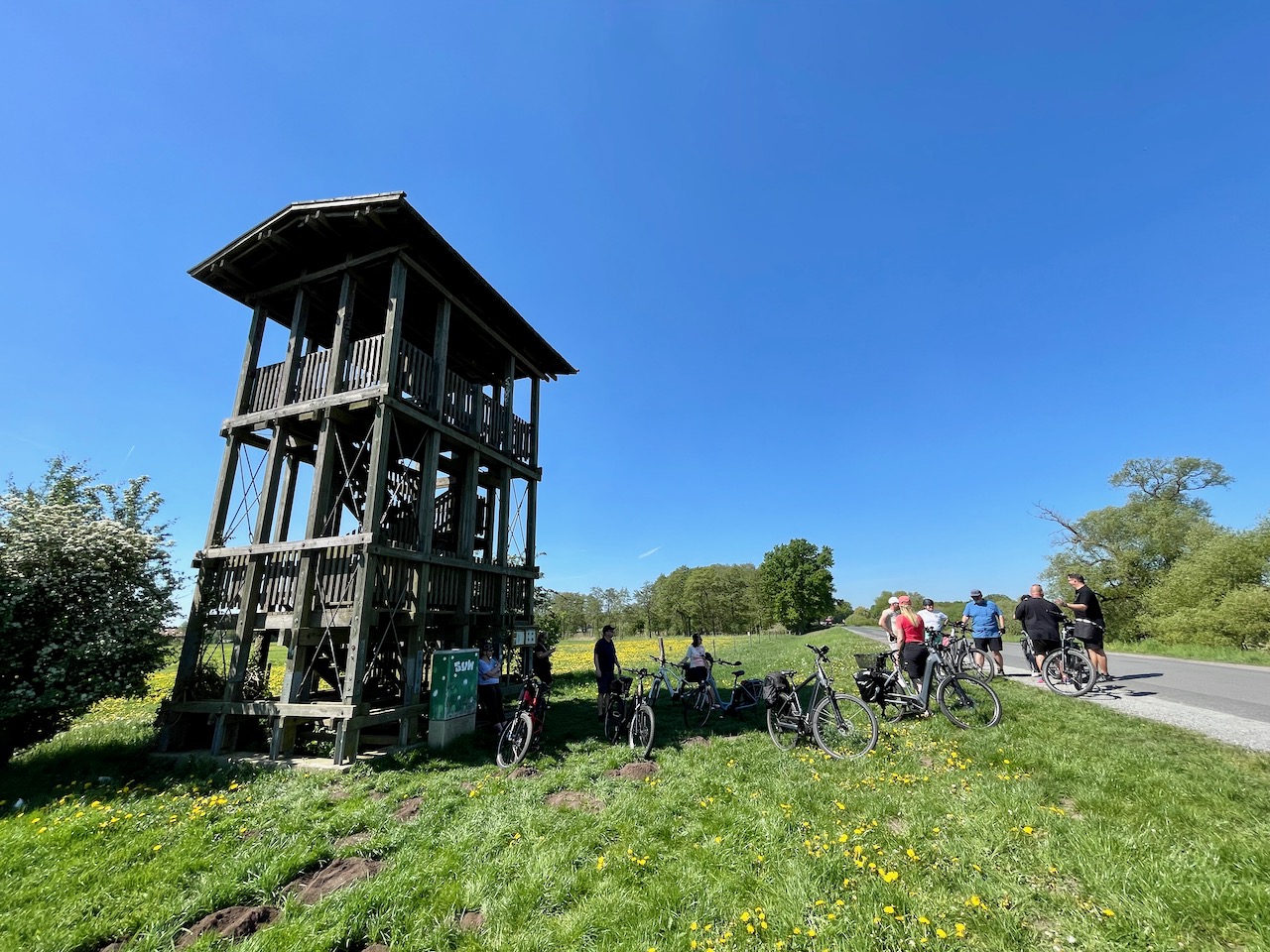 Fahrradtour im Blockland, Blick auf einen Aussichtsturm rundherum Fahrradfahrer bei der Pause