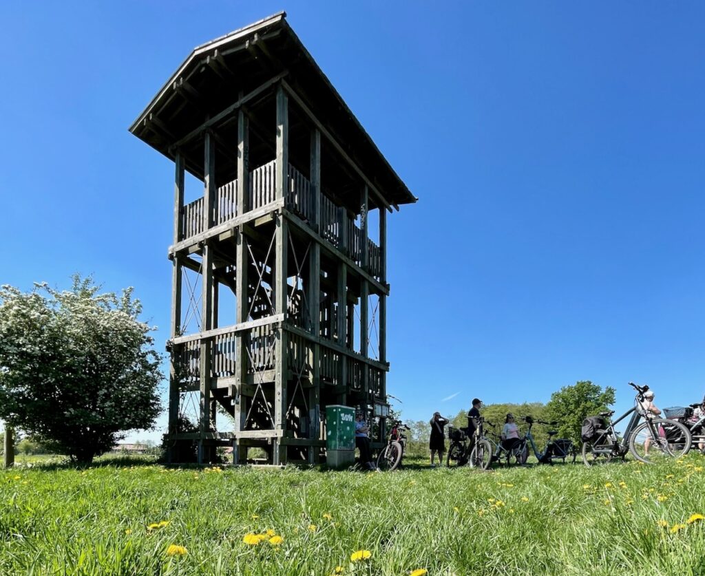 Fahrradtour im Blockland, Blick auf einen Aussichtsturm rundherum Fahrradfahrer bei der Pause