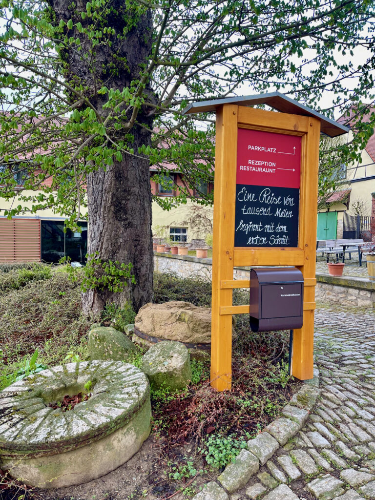 Eingangsbereich Schloss Auerstedt auf dem Schlossplatz mit Schild Aufschrift "Eine Reise von 1000 Meilen beginnt mit dem ersten Schritt"