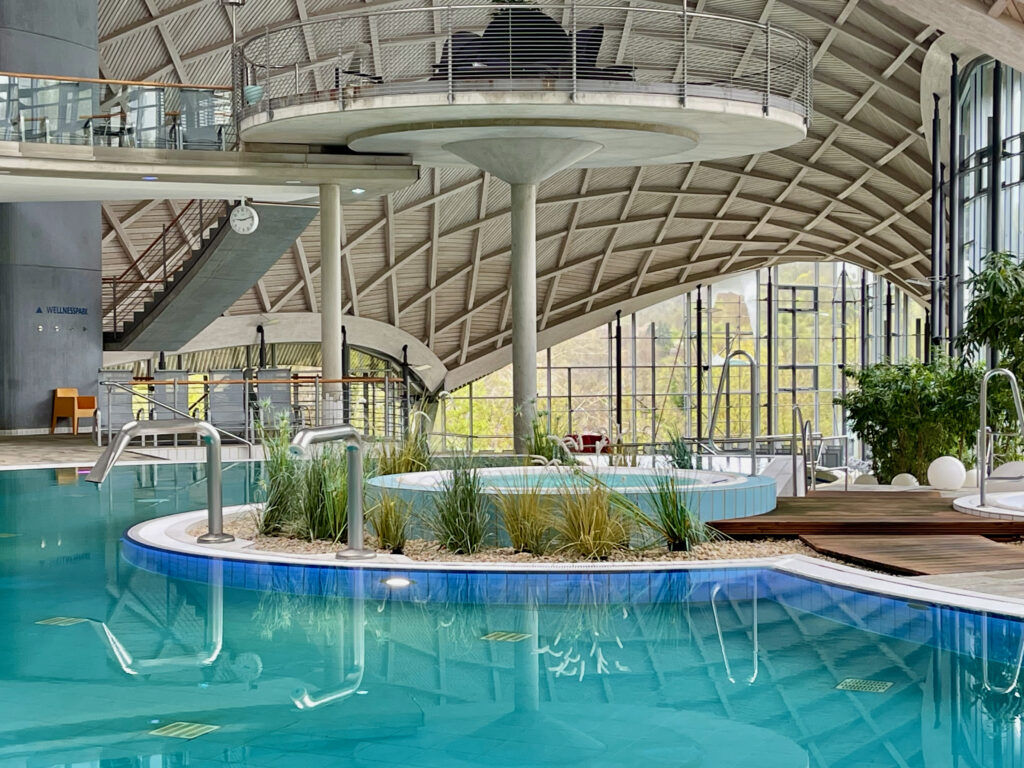 Blick auf das Schwimmbecken der Toskana Therme Bad Sulza, mit schwebenden Ruheinseln ueber den Wasserbecken