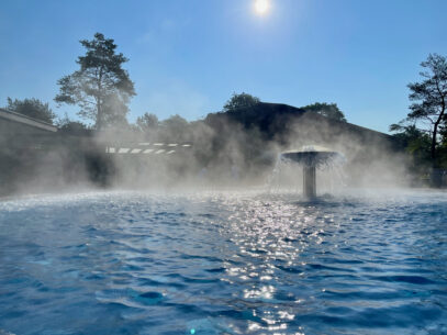 Boerde Therme Bad Sassendorf dampfendes Solebecken mit Thermalwasser im Sonnenlicht frueh am Morgen