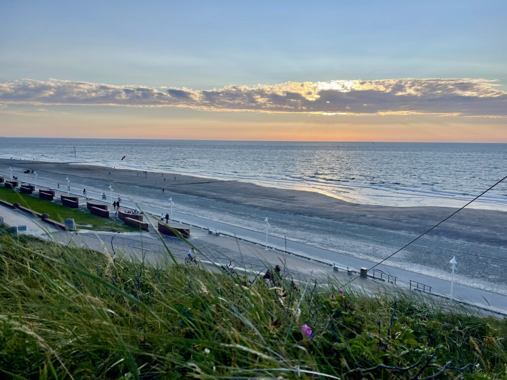 Sonnenuntergang am Strand von Norderney, Himmel und Meer verschwimmen in blau, orange und grau